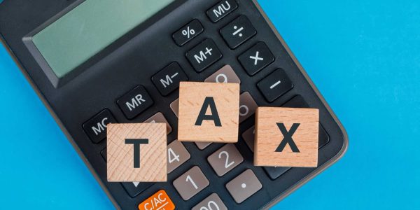 tax-planning-concept-with-wooden-cubes-calculator-blue-table-flat-lay (1)