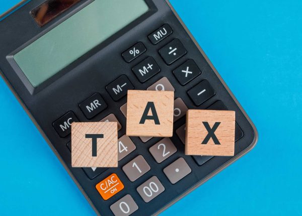 tax-planning-concept-with-wooden-cubes-calculator-blue-table-flat-lay (1)