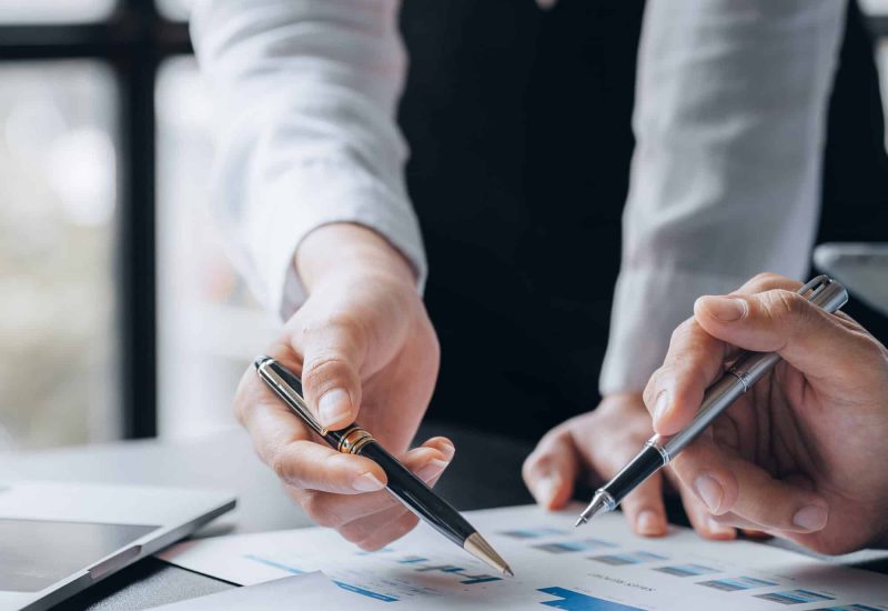 Two businessmen pointed to the material for the meeting, working Two businessmen pointed to the material for the meeting, working together to plan to develop and solve common business problems. Concept of business management for growth and quality.